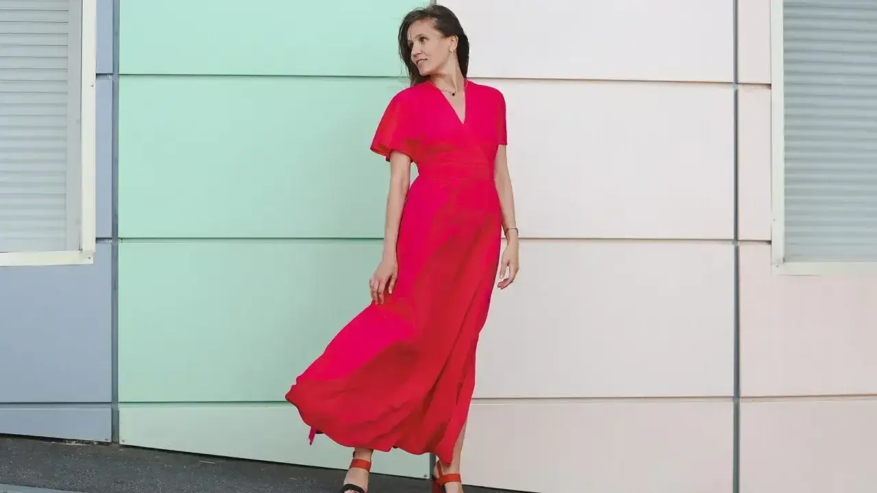 Elegancka kobieta w czerwonej sukience maxi, idealna odpowiedź na pytanie "w co się ubrać na wesele po 40".