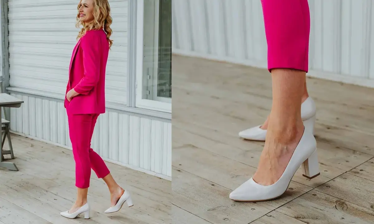 Elegancka kobieta w fuksjowym garniturze i białych, płaskich butach do damskiego garnituru.