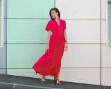 Elegancka kobieta w czerwonej sukience maxi, idealna odpowiedź na pytanie "w co się ubrać na wesele po 40".