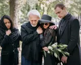 Smutna rodzina w czarnych strojach na cmentarzu. Wskazówki, jak ubrać się na pogrzeb: elegancja i powaga.
