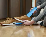 Jak odświeżyć buty w środku? Włóż niebieskie wkładki do brązowych sneakersów, by zapewnić komfort i świeżość.
