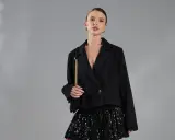 Elegancka kobieta w czarnym żakiecie i błyszczącej spódnicy cekinowej. Stylowe spódnica cekinowa stylizacje na wieczór.