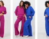 Trzy kobiety prezentują zestawy odzieży w stylu elegancki sportowy: fuksjowe i niebieskie dresy z szerokimi nogawkami.