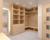 Jasna, przestronna garderoba w stylu quiet luxury. Drewniane półki i szuflady, puste wieszaki, drzwi z matowego szkła.