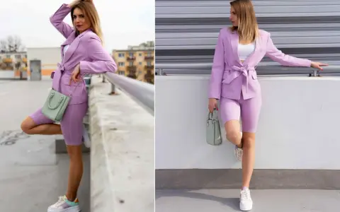 Kobieta w stylizacji w kolorze wrzosowym: marynarka, kolarki i sneakersy. W ręku trzyma miętową torebkę.