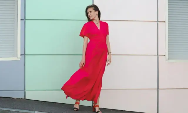 Elegancka kobieta w czerwonej sukience maxi, idealna odpowiedź na pytanie "w co się ubrać na wesele po 40".