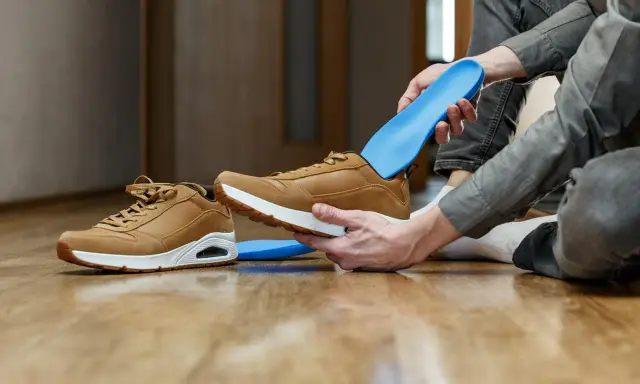 Jak odświeżyć buty w środku? Włóż niebieskie wkładki do brązowych sneakersów, by zapewnić komfort i świeżość.