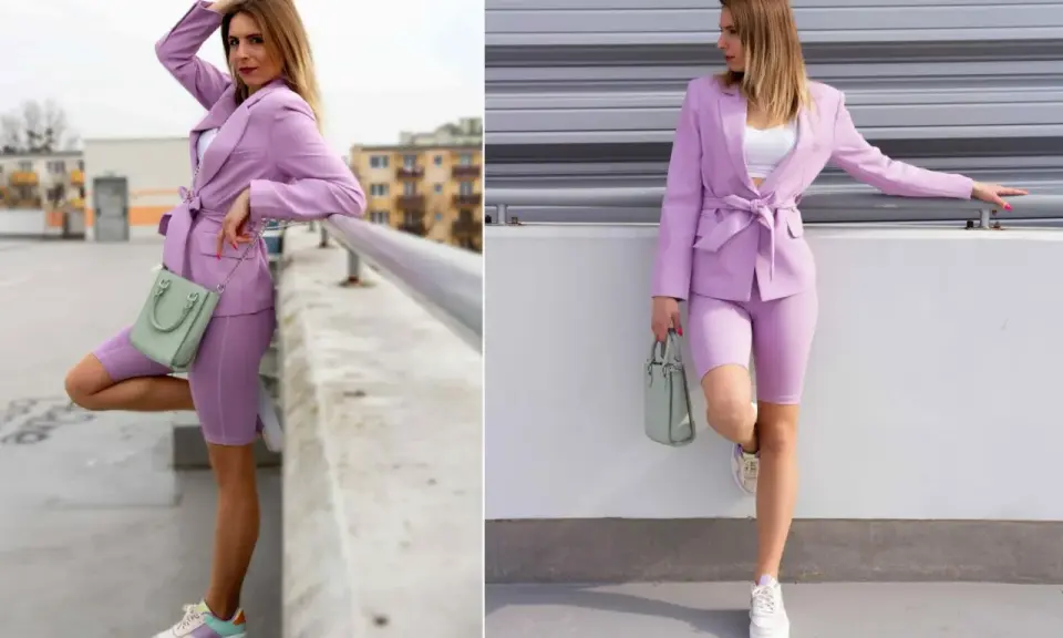 Kobieta w stylizacji w kolorze wrzosowym: marynarka, kolarki i sneakersy. W ręku trzyma miętową torebkę.
