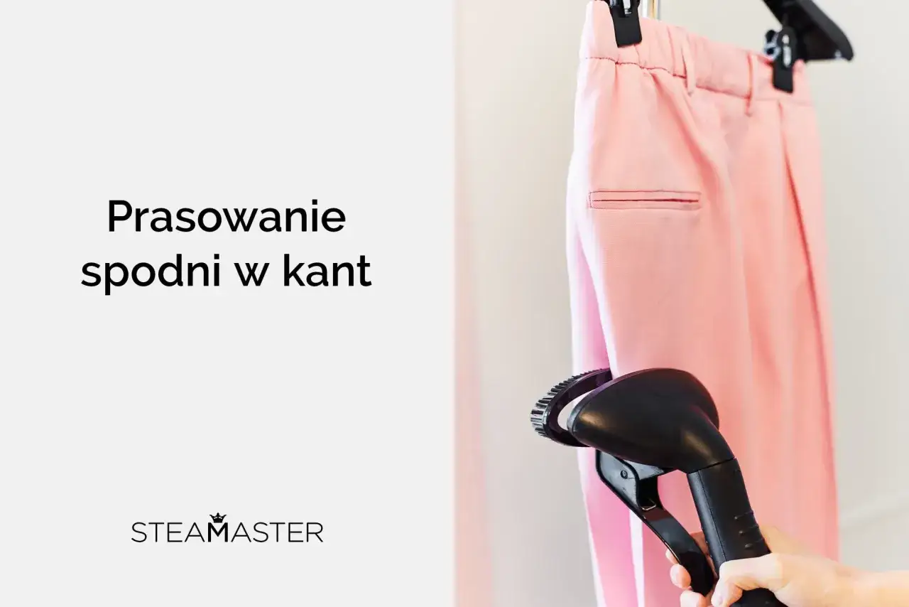Różowe spodnie w kant wiszą na wieszaku, a ręka trzyma parownicę, gotową do prasowania.