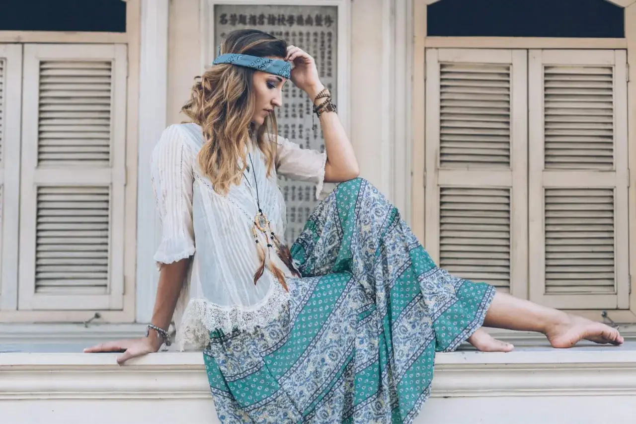Dziewczyna w stylu boho, z opaską na głowie i zwiewną sukienką, przypomina wolnego ducha, jak dzieci kwiaty. Jej moda jest inspirowana naturą.
