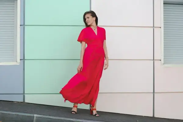 Elegancka kobieta w czerwonej sukience maxi, idealna odpowiedź na pytanie "w co się ubrać na wesele po 40".